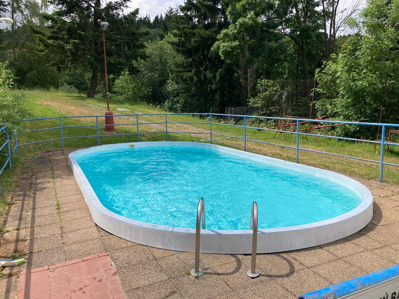 Venkovní bazén v kempu obklopený stromy